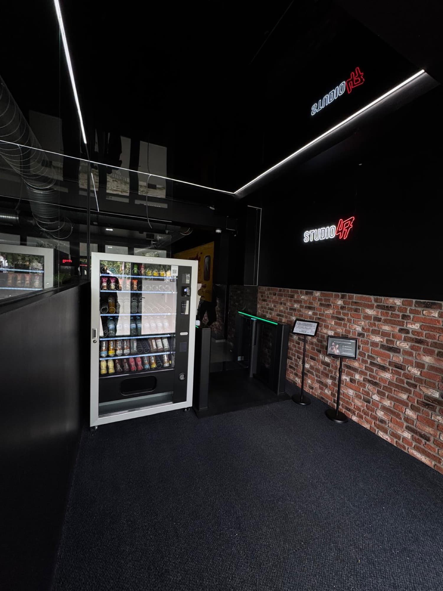 Eingangsbereich von Studio47 Berlin-Buckow mit Vendvibe-Verkaufsautomat und Neon-Logo